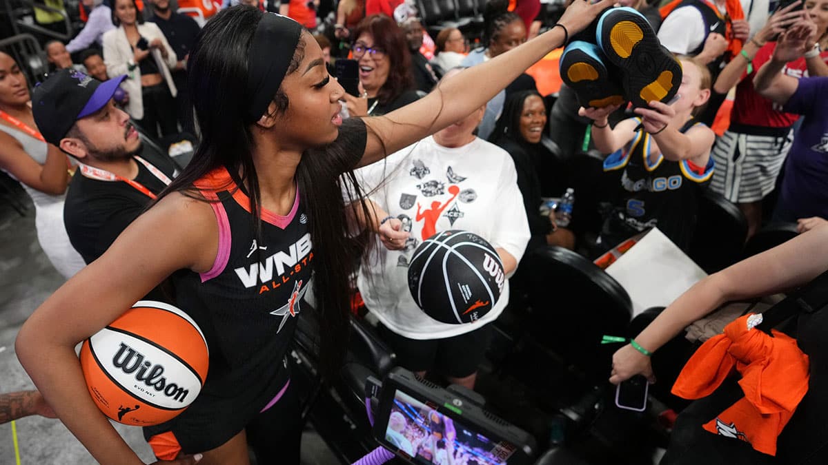 Team WNBA forward Angel Reese (5) hands off her shoes to a young fan after the WNBA All-Star Game at Footprint Center in Phoenix on Saturday, July 20, 2024.
