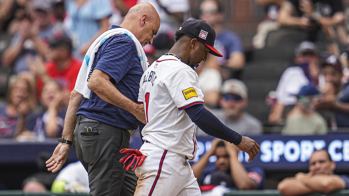 Jul 21, 2024; Cumberland, Georgia, USA; Atlanta Braves second baseman Ozzie Albies (1) is assisted off the field after being injured during a play against the St. Louis Cardinals during the ninth inning at Truist Park. Mandatory Credit: Dale Zanine-USA TODAY Sports