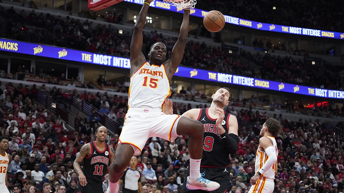 Apr 17, 2024; Chicago, Illinois, USA; Atlanta Hawks center Clint Capela (15) dunks the ball on Chicago Bulls center Nikola Vucevic (9) during the second half during a play-in game of the 2024 NBA playoffs at United Center. Mandatory Credit: David Banks-USA TODAY Sports