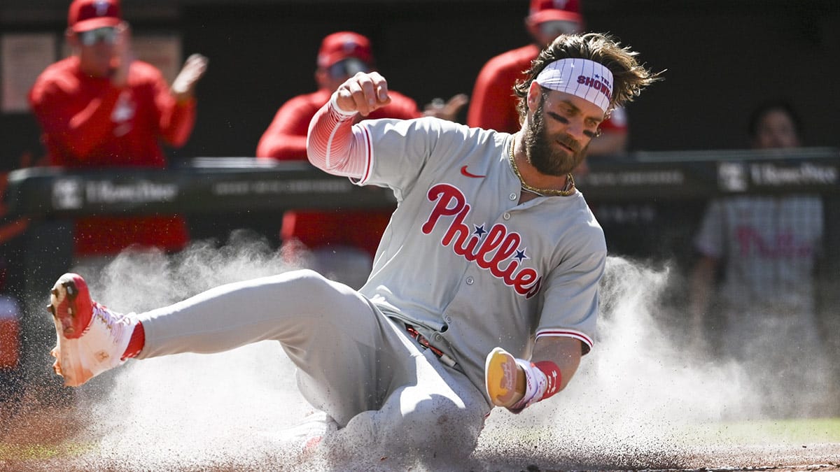 Jun 15, 2024; Baltimore, Maryland, USA; Philadelphia Phillies first baseman Bryce Harper (3) slides to score during the first inning against the Baltimore Orioles at Oriole Park at Camden Yards.