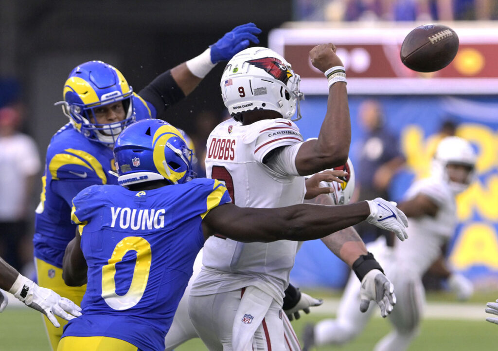 Los Angeles Rams linebacker Byron Young (0) knocks the ball out of the hands of Arizona Cardinals quarterback Joshua Dobbs (9) to force a fumble recovered by the Arizona Cardinals during the second half at SoFi Stadium. 