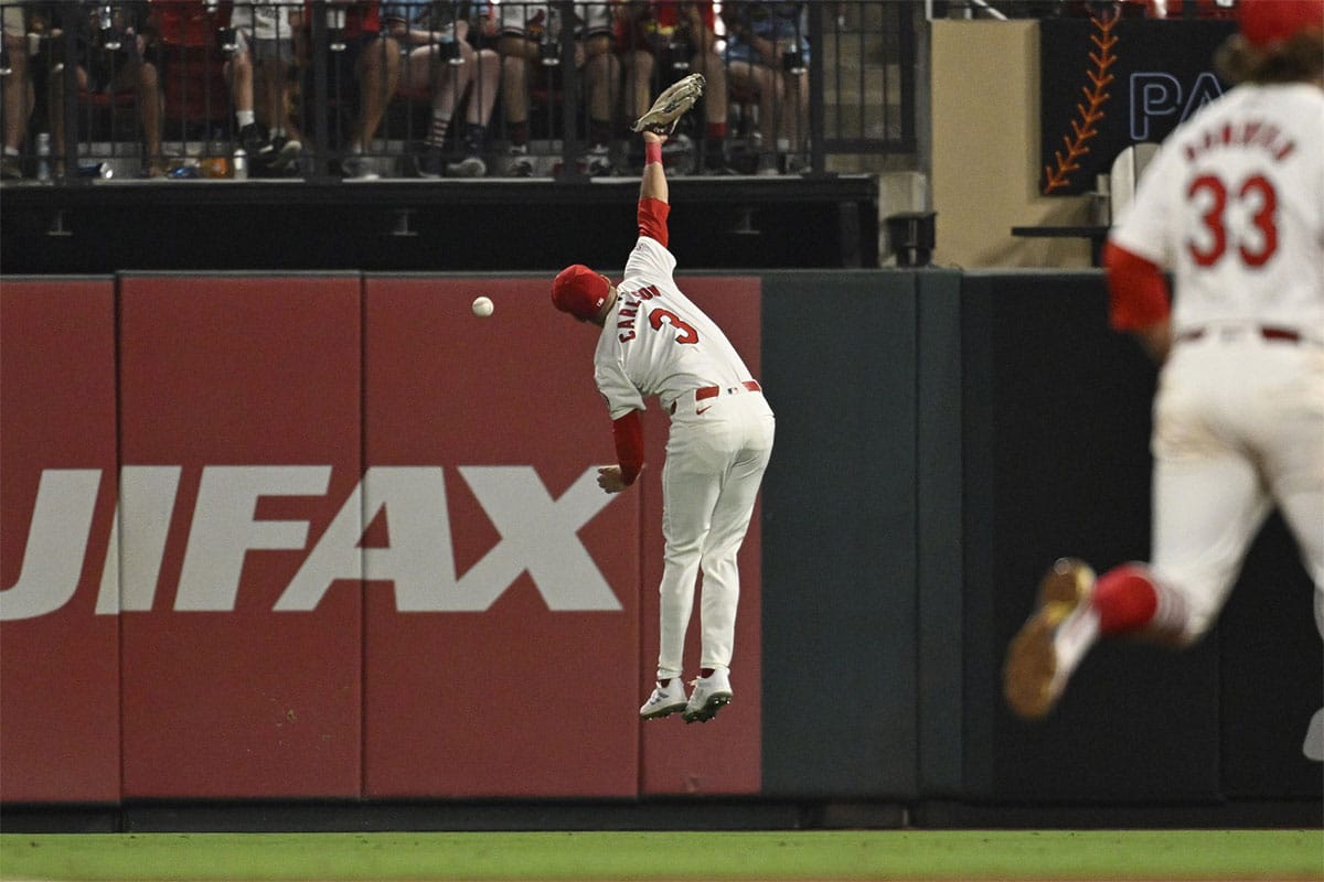 St. Louis Cardinals left fielder Dylan Carlson (3) misses a triple hit by Washington Nationals center fielder Jacob Young (30) during the tenth inning at Busch Stadium.