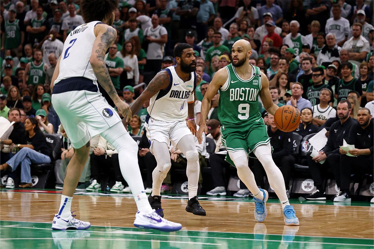 Boston Celtics guard Derrick White (9) dribbles the ball against Dallas Mavericks guard Kyrie Irving (11) and center Dereck Lively II (2) during the fourth quarter in game five of the 2024 NBA Finals at TD Garden. 