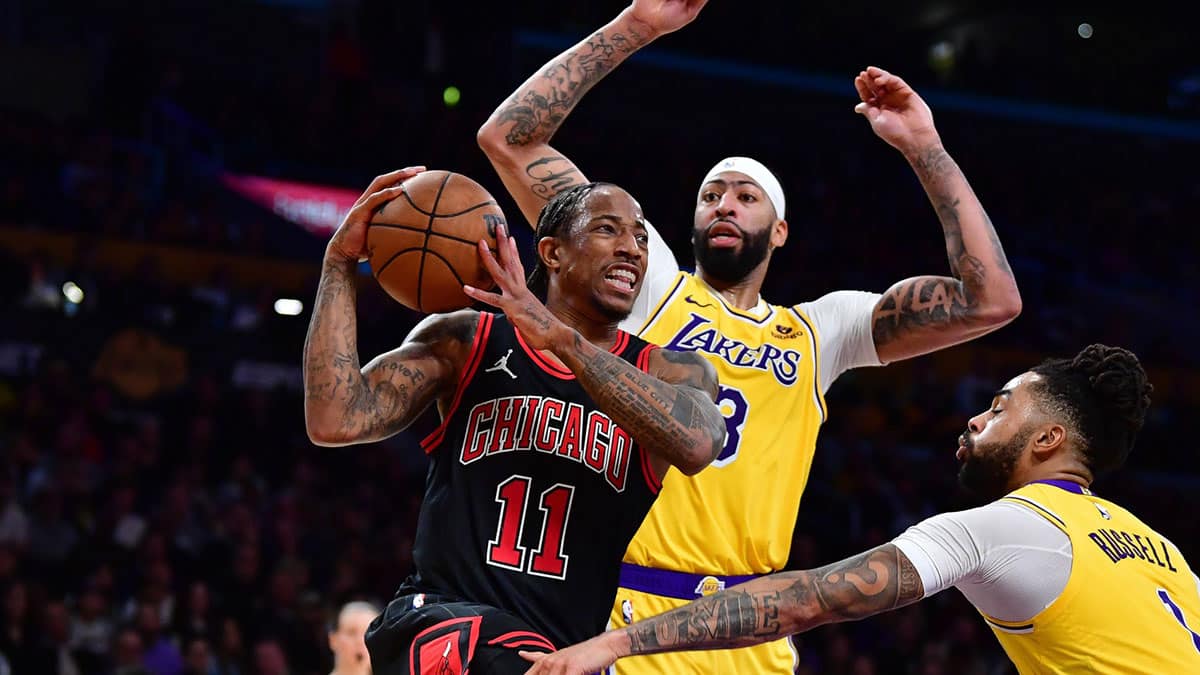 Jan 25, 2024; Los Angeles, California, USA; Chicago Bulls forward DeMar DeRozan (11) moves the ball against Los Angeles Lakers forward Anthony Davis (3) and guard D'Angelo Russell (1) during the second half at Crypto.com Arena. Mandatory Credit: Gary A. Vasquez-USA TODAY Sports