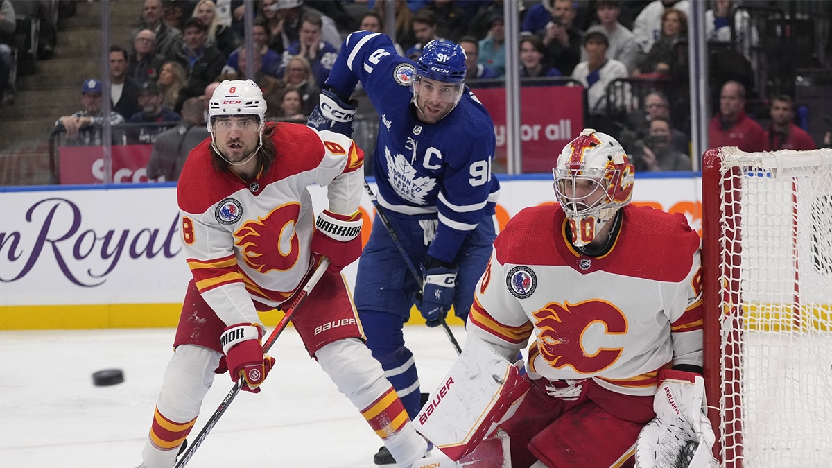 Calgary Flames goaltender Dan Vladar (80) goes to make a save as defenseman Chris Tanev (8) and Toronto Maple Leafs forward John Tavares (91) wait for a rebound during the third period at Scotiabank Arena.