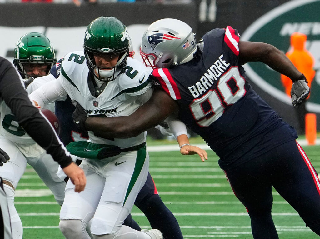 New York Jets quarterback Zach Wilson (2) scaked by New England Patriots defensive tackle Christian Barmore (90) at MetLife Stadium.