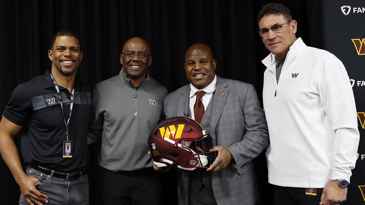 Feb 23, 2023; Ashburn, Virginia, USA; Eric Bieniemy (holding helmet) poses with (L-R) Washington Commanders team president Jason Wright, general manager Martin Mayhew, and head coach Ron Rivera, after being introduced as the new Commanders offensive coordinator and assistant head coach during an introductory press conference at Commanders Park. Mandatory Credit: Geoff Burke-USA TODAY Sports