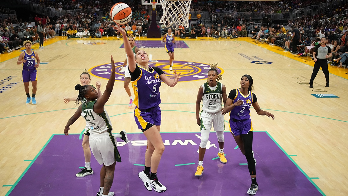 LA Sparks forward Dearica Hamby (5) shoots the ball against Seattle Storm guard Jordan Horston (23) and guard Jewell Loyd (24) in the second half at Crypto.com Arena.