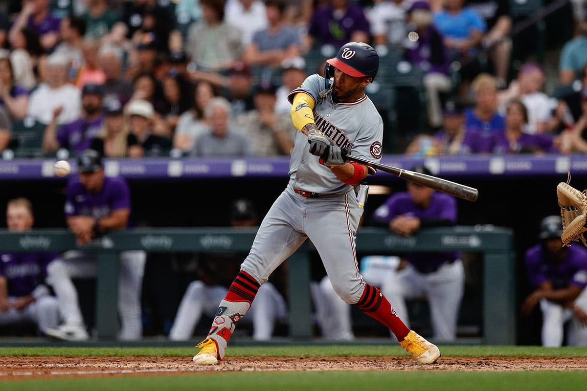 Washington Nationals designated hitter Eddie Rosario (8) hits a sacrifice fly RBI in the fourth inning against the Colorado Rockies at Coors Field.