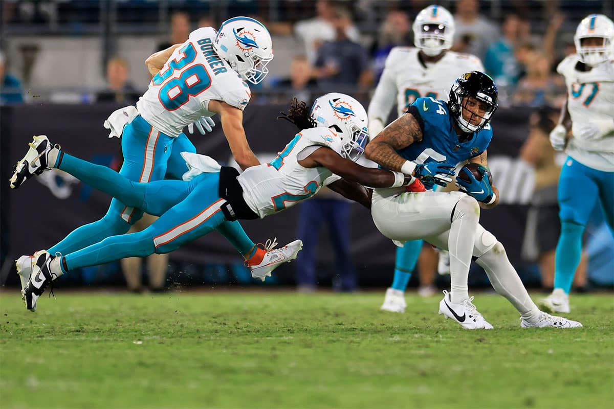 Jacksonville Jaguars wide receiver Elijah Cooks (84) is tackled by Miami Dolphins cornerback Cam Smith (24) during the third quarter of a preseason matchup Saturday, Aug. 26, 2023 at EverBank Stadium in Jacksonville, Fla. The game was suspended in the fourth after Miami Dolphins wide receiver Daewood Davis (87) was injured on a play with the Jaguars leading 31-18.