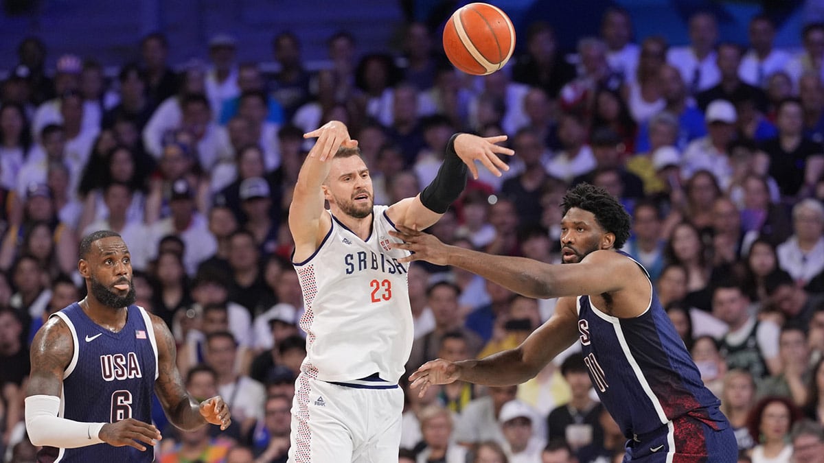  Serbia shooting guard Marko Guduric (23) passes against United States guard Lebron James (6) and center Joel Embiid (11) in the second quarter against Serbia during the Paris 2024 Olympic Summer Games at Stade Pierre-Mauroy.