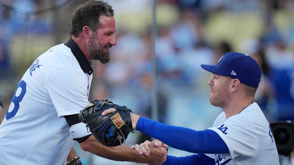 Los Angeles Dodgers former pitcher Eric Gagne (left) shakes hands with first baseman Freddie Freeman (5) during the game against the Arizona Diamondbacks at Dodger Stadium.