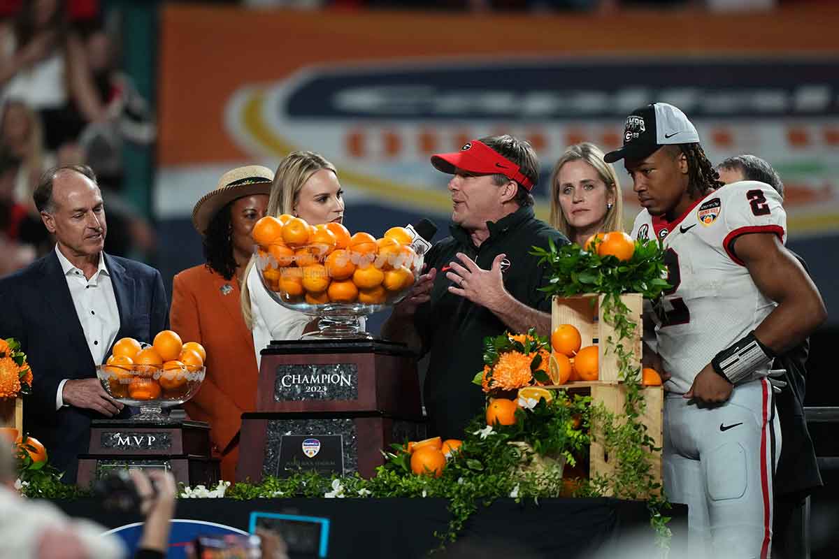 Georgia Bulldogs head coach Kirby Smart and Georgia Bulldogs running back Kendall Milton (2) react with the trophy after defeating Florida State Seminoles in the 2023 Orange Bowl at Hard Rock Stadium. 