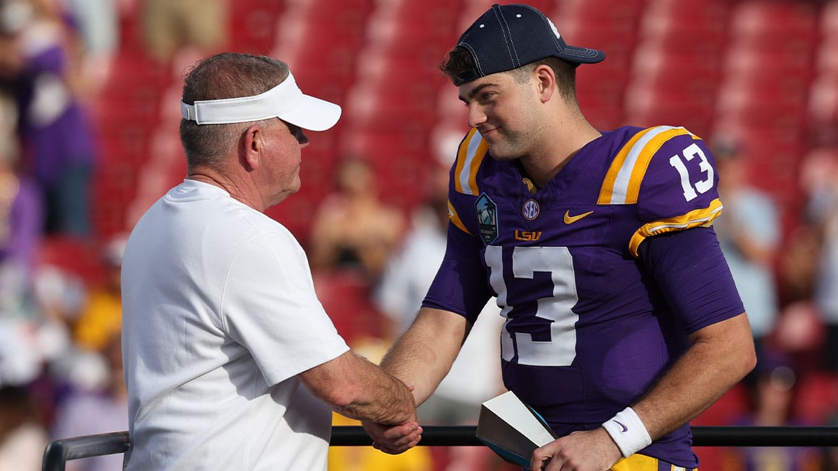  LSU Tigers quarterback Garrett Nussmeier (13) is congratulated by head coach Brian Kelly after being awarded the MVP award after beating the Wisconsin Badgers in the ReliaQuest Bowl at Raymond James Stadium. 