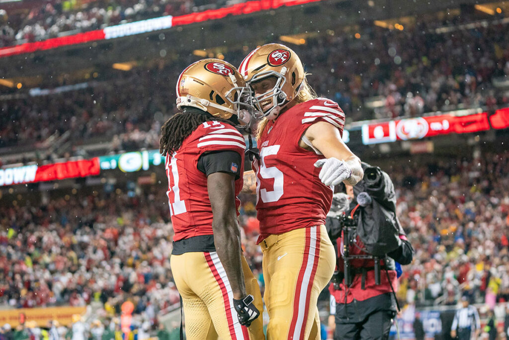 San Francisco 49ers tight end George Kittle (85) is congratulated by wide receiver Brandon Aiyuk (11) after scoring a touchdown during the second quarter in a 2024 NFC divisional round game against the Green Bay Packers at Levi's Stadium.