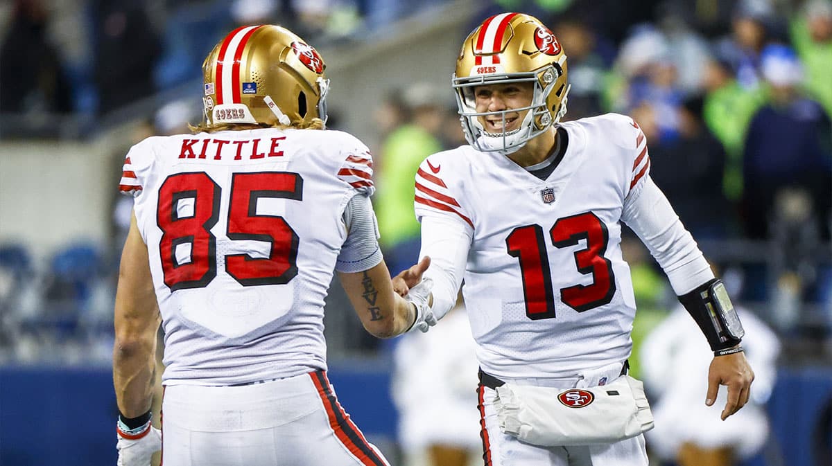 San Francisco 49ers quarterback Brock Purdy (13) celebrates with tight end George Kittle (85) during the late fourth quarter against the Seattle Seahawks at Lumen Field.