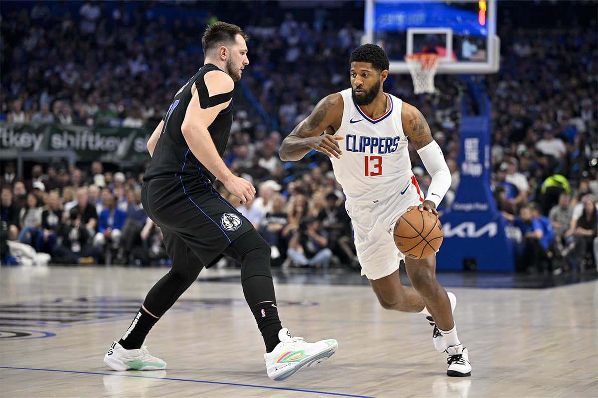 LA Clippers forward Paul George (13) moves the ball past Dallas Mavericks guard Luka Doncic (77) during the first quarter during game six of the first round for the 2024 NBA playoffs at American Airlines Center.