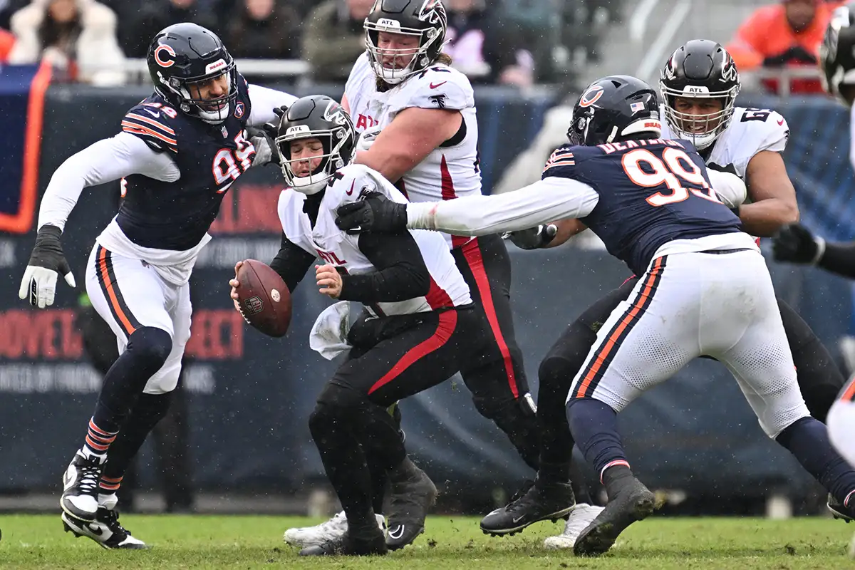 Dec 31, 2023; Chicago, Illinois, USA; Atlanta Falcons quarterback Taylor Heinicke (4) is sacked by Chicago Bears defensive lineman Gervon Dexter Sr. (99) in the first half at Soldier Field.