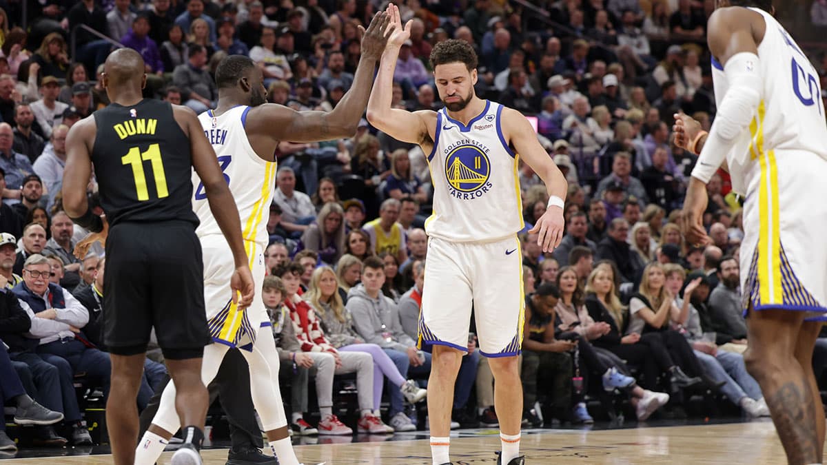 Feb 12, 2024; Salt Lake City, Utah, USA; Golden State Warriors guard Klay Thompson (11) and forward Draymond Green (23) celebrate a basket and a foul against the Utah Jazz during the second half at Delta Center. Mandatory Credit: Chris Nicoll-USA TODAY Sports
