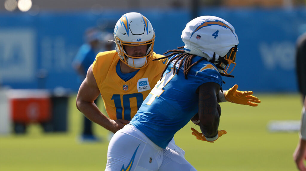 Los Angeles Chargers quarterback Justin Herbert (10) hands a ball off to running back Gus Edwards (4) during the first day of training camp at The Bolt. 
