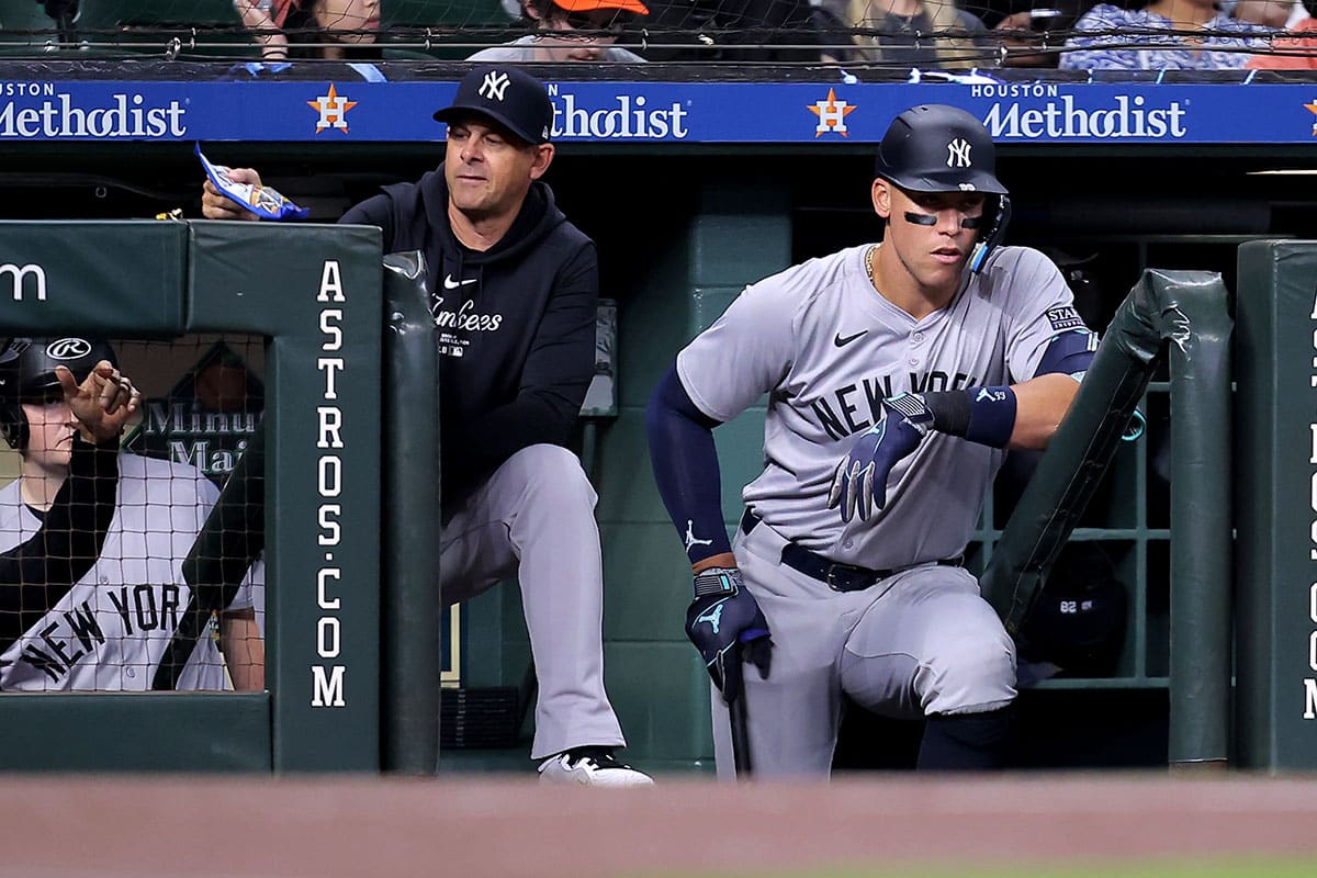 New York Yankees manager Aaron Boone (17) and New York Yankees designated hitter Aaron Judge (99) watch the action from the dugout against the Houston Astros during the first inning at Minute Maid Park