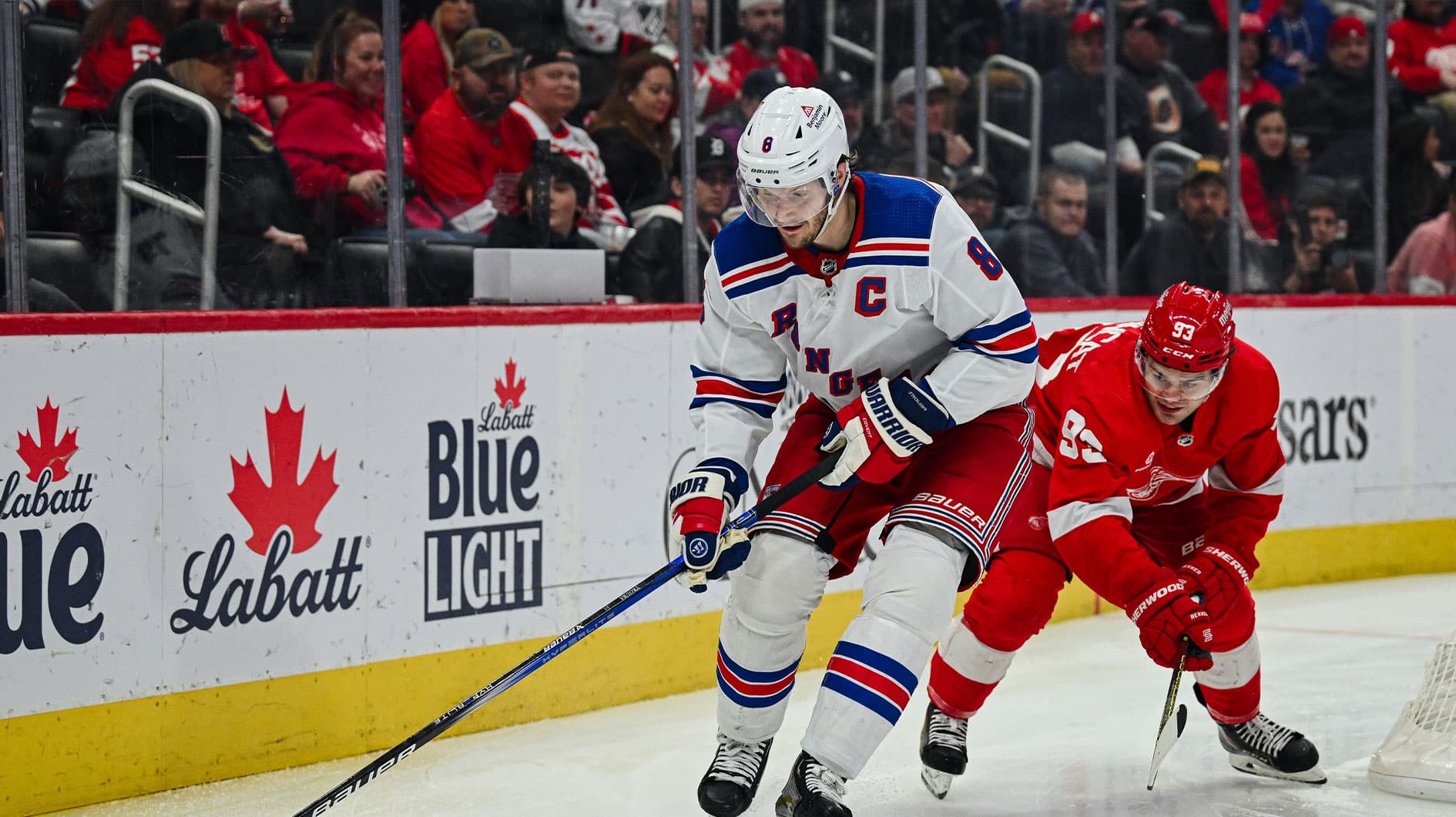 New York Rangers defenseman Jacob Trouba (8) and Detroit Red Wings right wing Alex DeBrincat (93) battle for the puck during the second period at Little Caesars Arena.