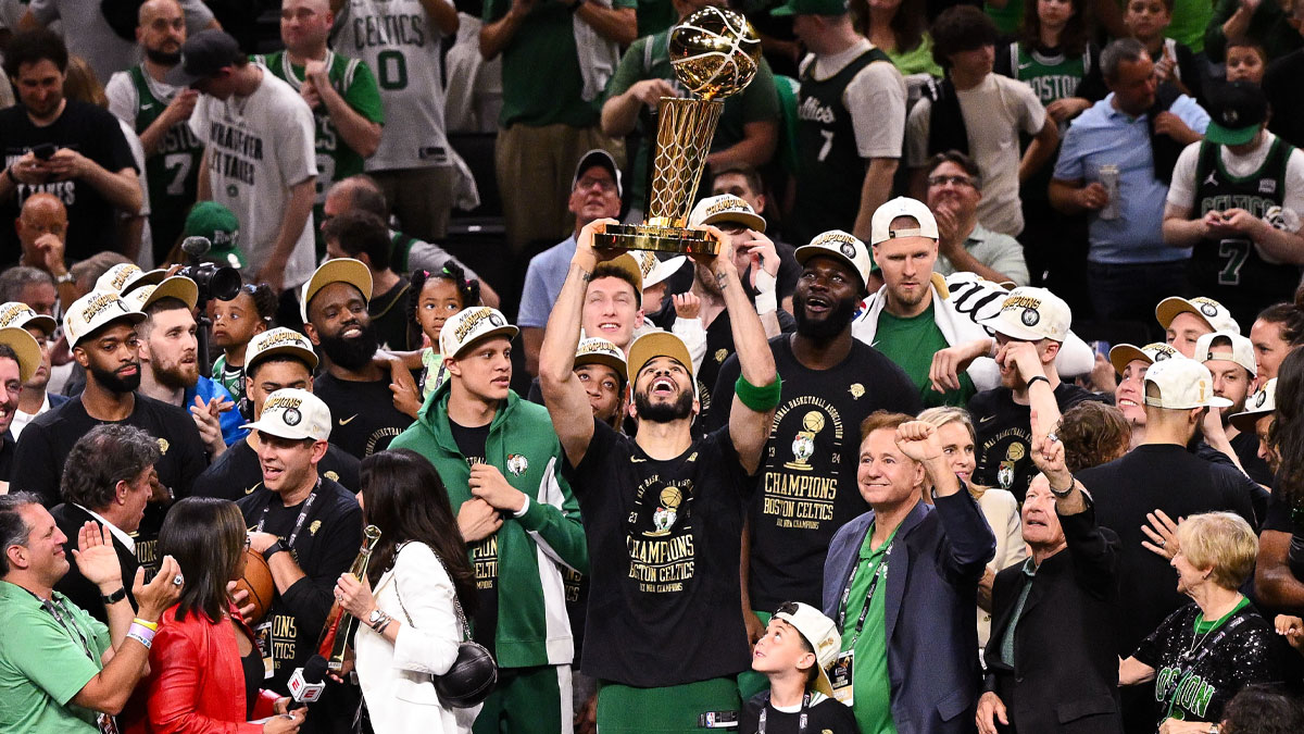 Boston Celtics forward Jayson Tatum (0) holds up the Larry O'Brien Championship Trophy after the Celtics beat the Dallas Mavericks in game five of the 2024 NBA Finals at the TD Garden.