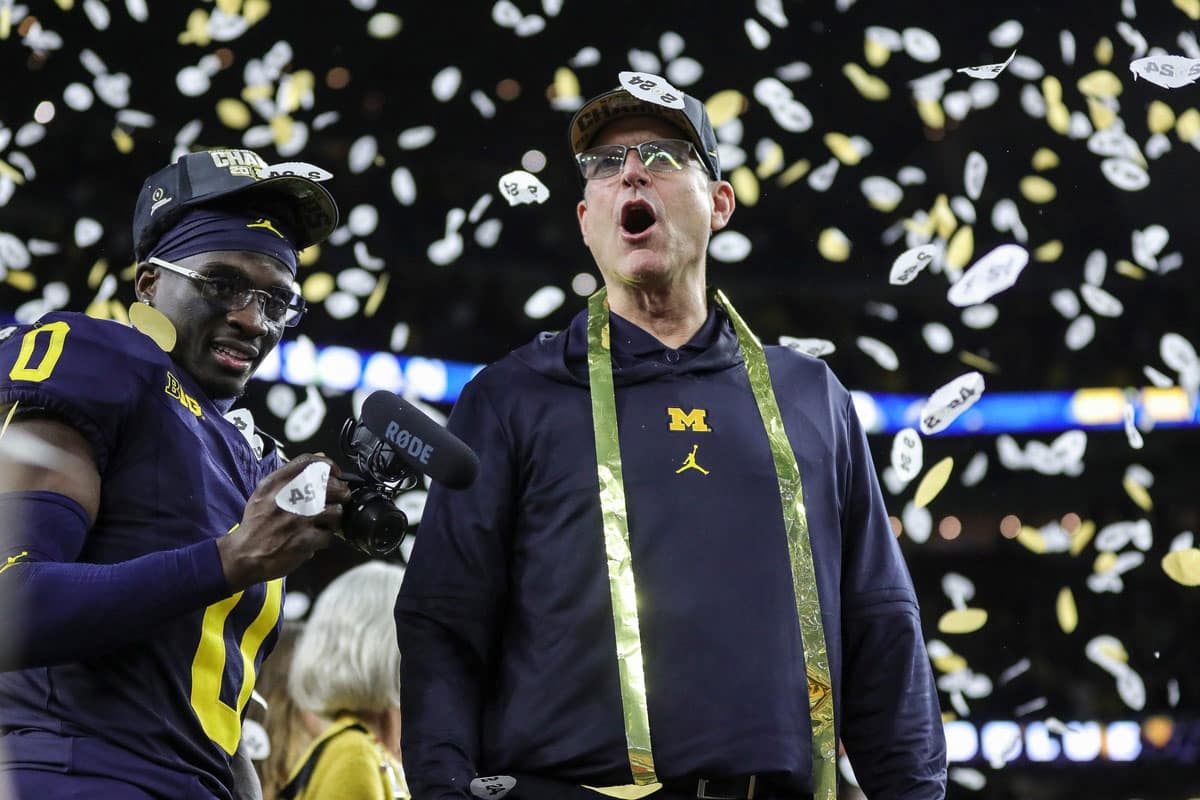 Michigan head coach Jim Harbaugh celebrates during the trophy presentation after the 34-13 win over Washington at the national championship game at NRG Stadium