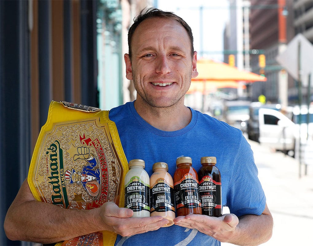 Professional competitive eater Joey Chestnut displays his new dipping sauces. The 2019 Nathan's Hot Dog Eating Champion will be giving away 1,000 bottles of his new line of dipping sauces to fans this Thursday on Monument Circle. Joey Chestnut Giving Away1 000 Bottles Of His New Line Of Dipping Sauces To Fans