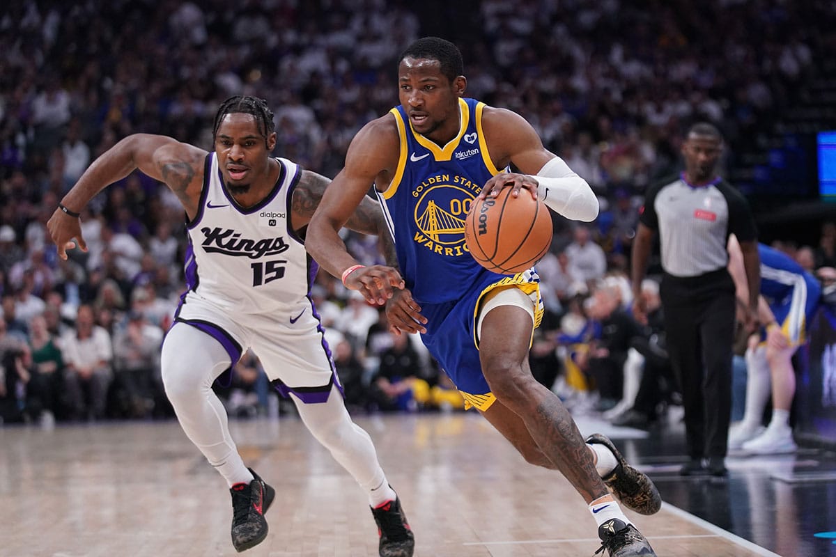 Golden State Warriors forward Jonathan Kuminga (00) dribbles past Sacramento Kings guard Davion Mitchell (15) in the second quarter during a play-in game of the 2024 NBA playoffs at the Golden 1 Center.