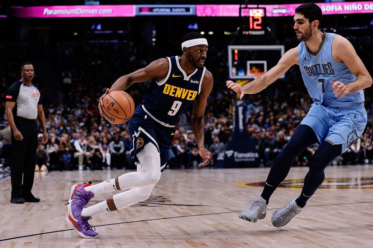 Denver Nuggets forward Justin Holiday (9) controls the ball as Memphis Grizzlies forward Santi Aldama (7) guards in the third quarter at Ball Arena. 