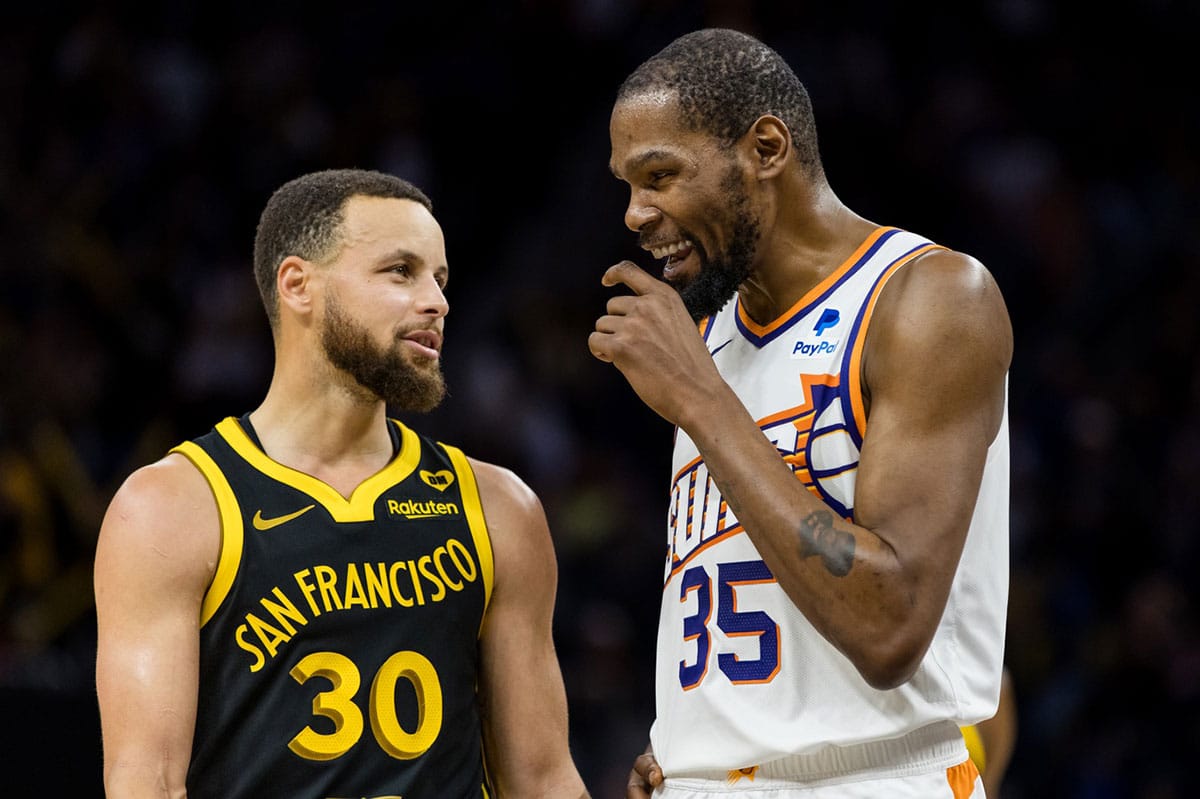 Golden State Warriors guard Stephen Curry (30) and Phoenix Suns forward Kevin Durant (35) talk during the second half at Chase Center.