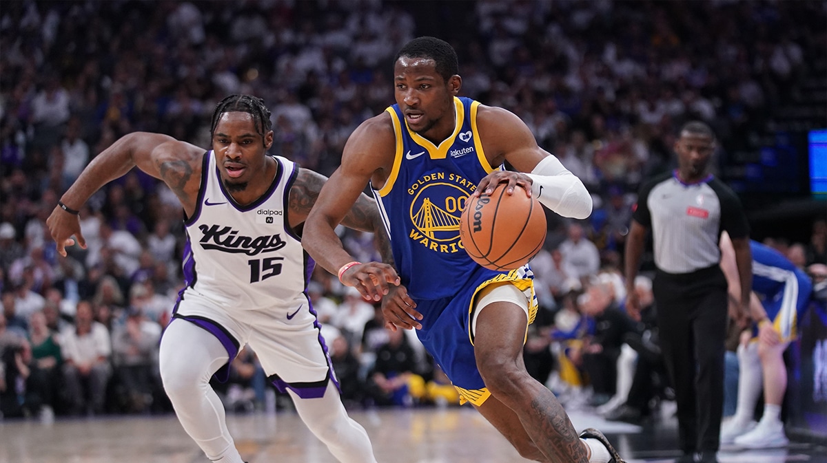 Golden State Warriors forward Jonathan Kuminga (00) dribbles past Sacramento Kings guard Davion Mitchell (15) in the second quarter during a play-in game of the 2024 NBA playoffs at the Golden 1 Center. 
