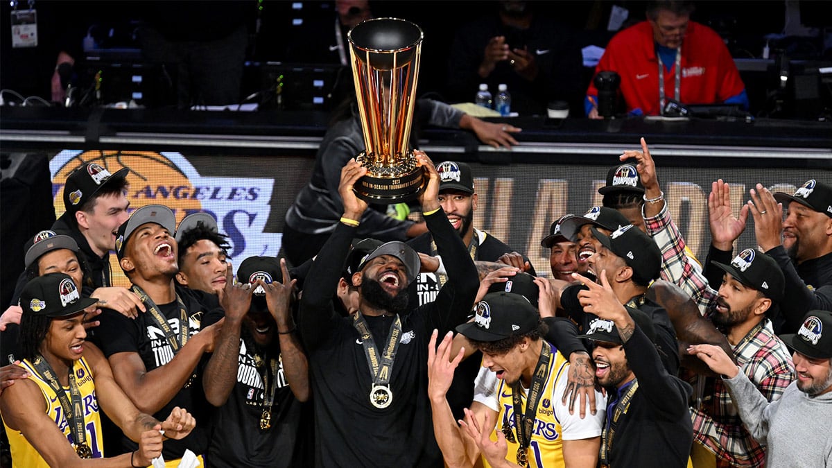 Los Angeles Lakers forward LeBron James (23) hoists the NBA Cup and celebrates with teammates after winning the NBA In-Season Tournament Championship game against the Indiana Pacers at T-Mobile Arena. 