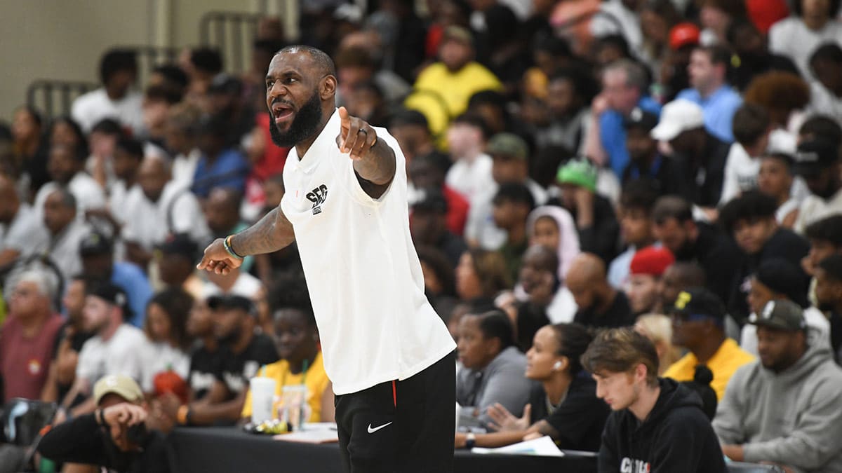 NBA star LeBron James coaches from the bench during the Strive for Greatness and Mokan Elite basketball game at the fourth day of the Nike Peach Jam at Riverview Park Activities Center.