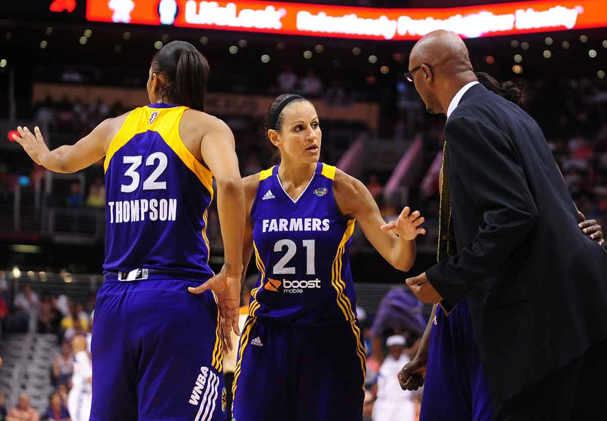 Sep 3, 2011; Phoenix, AZ, USA; Los Angeles Sparks head coach Joe Bryant talks with players guard Ticha Penicheiro (21) and forward Tina Thompson (32) during the first half against the Phoenix Mercury at the US Airways Center. The Mercury defeated the Sparks, 93-77. Mandatory Credit: Jennifer Stewart-USA TODAY Sports
