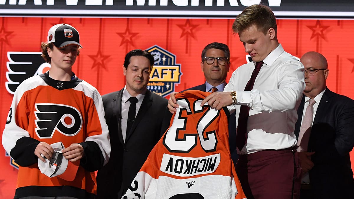 Philadelphia Flyers draft pick Matvei Michkov puts on his sweater after being selected with the seventh pick in round one of the 2023 NHL Draft at Bridgestone Arena.