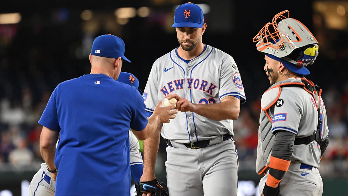 New York Mets starting pitcher David Peterson (23) hands the ball to manager Carlos Mendoza (64) while walking off the mound against the Washington Nationals during the seventh inning at Nationals Park. 
