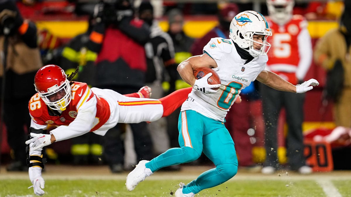 Miami Dolphins wide receiver Braxton Berrios (0) returns a kickoff against Kansas City Chiefs safety Deon Bush (26) during the second half of a 2024 AFC wild card game at GEHA Field at Arrowhead Stadium. 