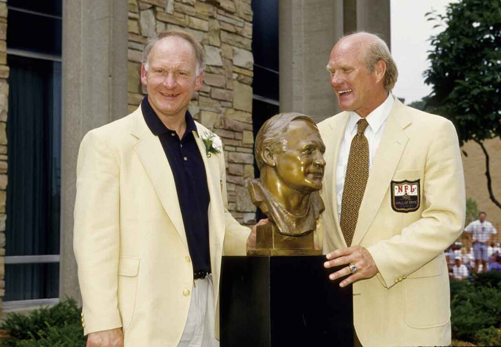 Pittsburgh Steelers former center Mike Webster poses with his bust and portrait alongside Terry Bradshaw at Webster's enshrinement into the Pro Football Hall of Fame