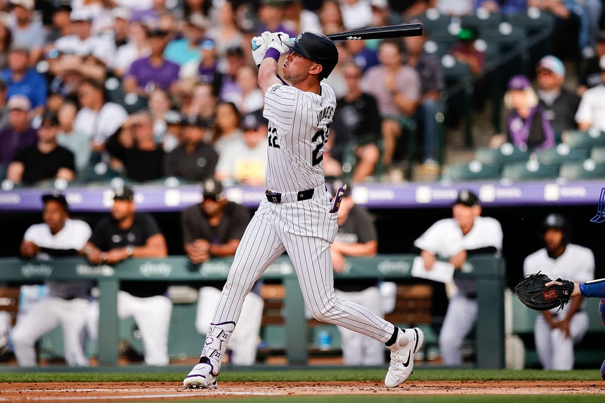Colorado Rockies left fielder Nolan Jones (22) hits a sacrifice fly RBI in the first inning against the Los Angeles Dodgers at Coors Field.