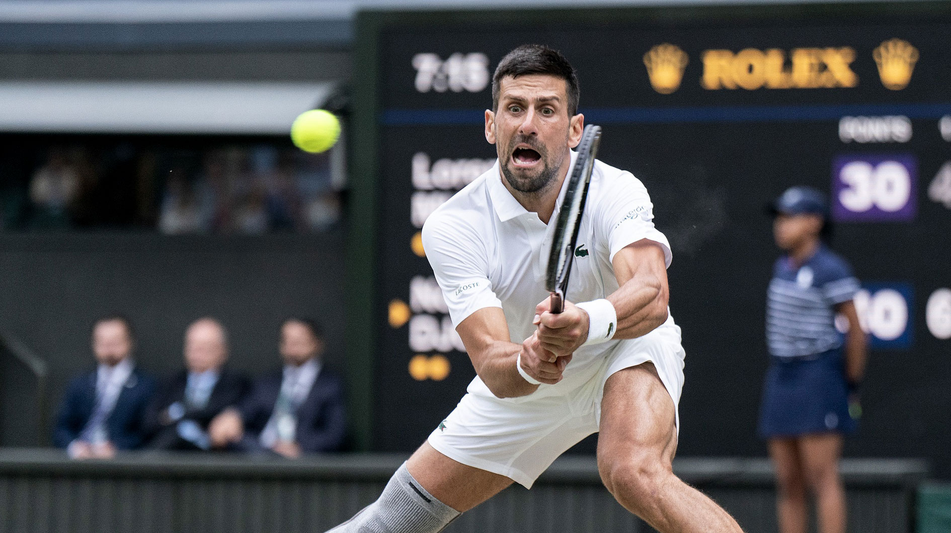 Novak Djokovic of Serbia returns a shot during his match against Lorenzo Musetti of Italy on day 12 at All England Lawn Tennis and Croquet Club.