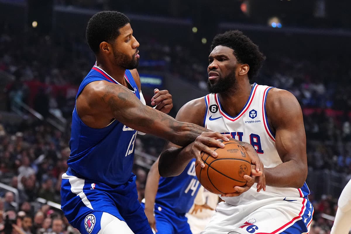 Philadelphia 76ers center Joel Embiid (21) is fouled by LA Clippers guard Paul George (13) in the first half at Crypto.com Arena