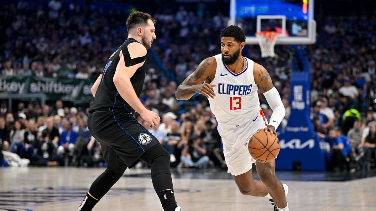 LA Clippers forward Paul George (13) moves the ball past Dallas Mavericks guard Luka Doncic (77) during the first quarter during game six of the first round for the 2024 NBA playoffs at American Airlines Center.