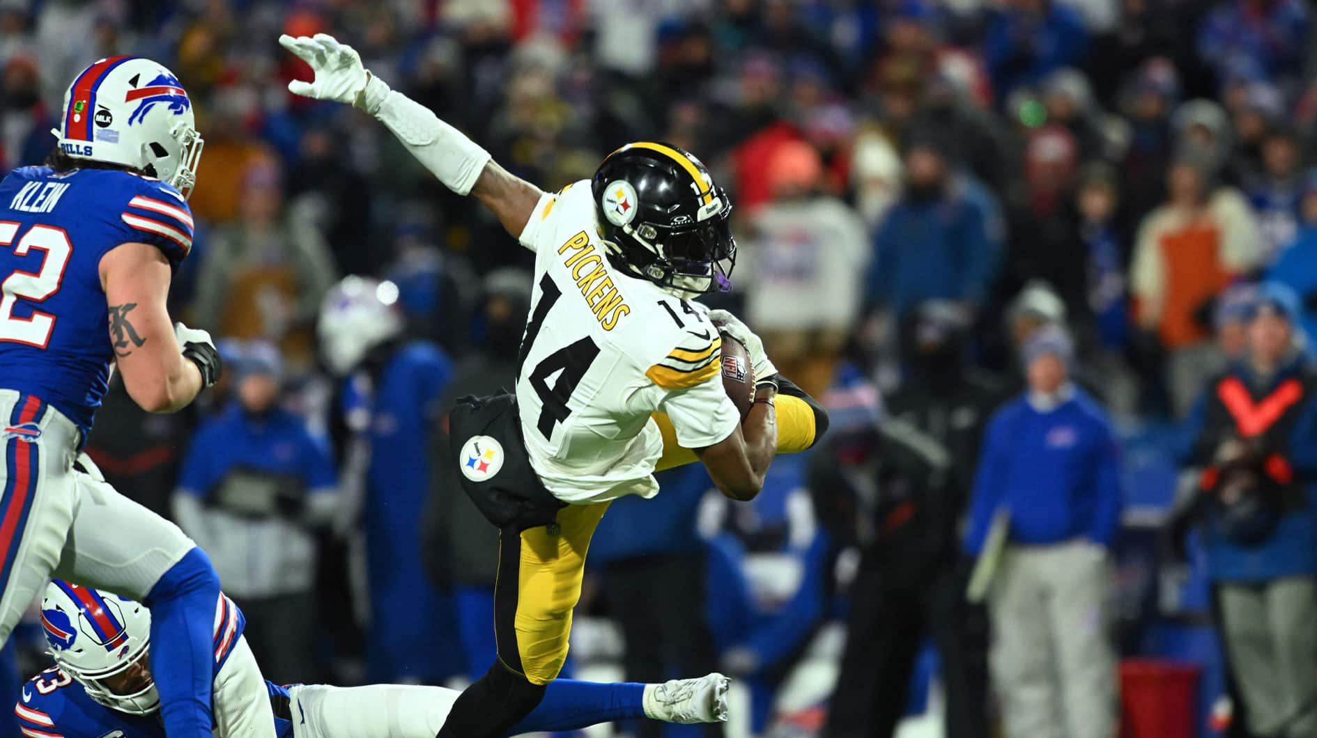 Pittsburgh Steelers wide receiver George Pickens (14) outs runs a tackle attempt by Buffalo Bills safety Micah Hyde (23) in the second half in a 2024 AFC wild card game at Highmark Stadium. 