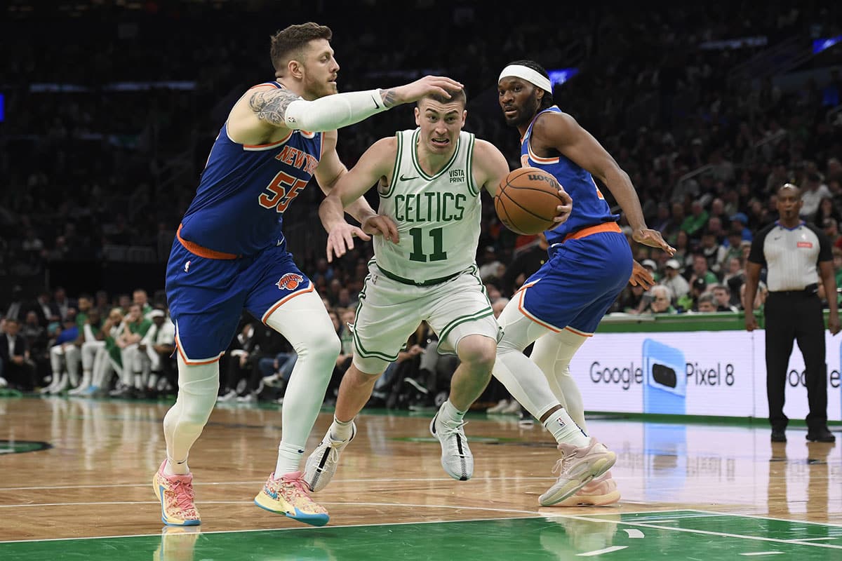 Boston Celtics guard Payton Pritchard (11) controls the ball while New York Knicks center Isaiah Hartenstein (55) and forward Precious Achiuwa (5) defend during the second half at TD Garden. 