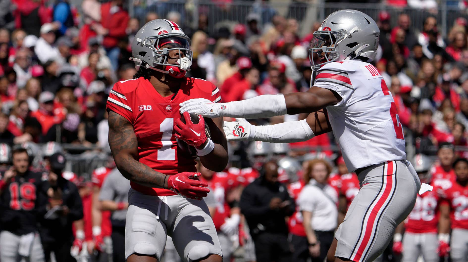 Ohio State Buckeyes running back Quinshon Judkins (1) of the scarlet team is tagged by Caleb Downs (2) of the grey team during the first half of the LifeSports spring football game at Ohio Stadium on Saturday.