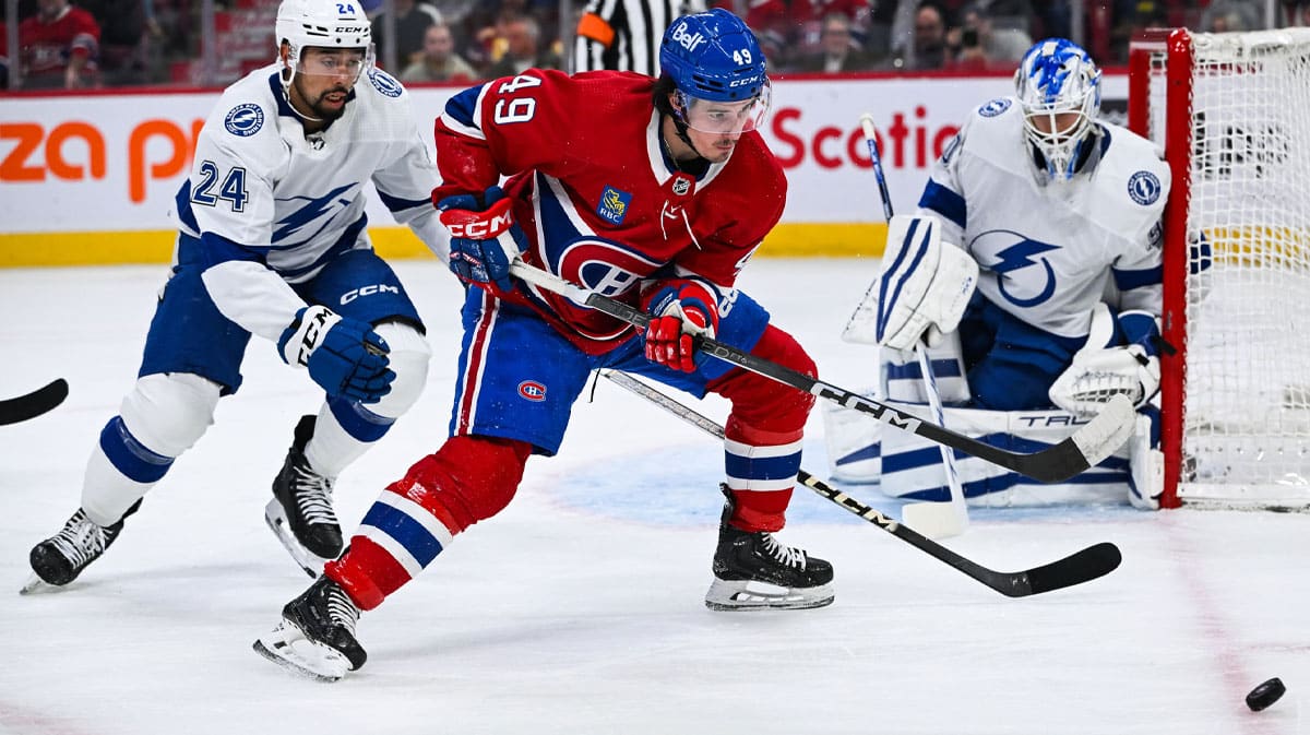 Montreal Canadiens left wing Rafael Harvey-Pinard (49) plays the puck against Tampa Bay Lightning defenseman Mathew Dumba (24) near the net during the first period at Bell Centre.