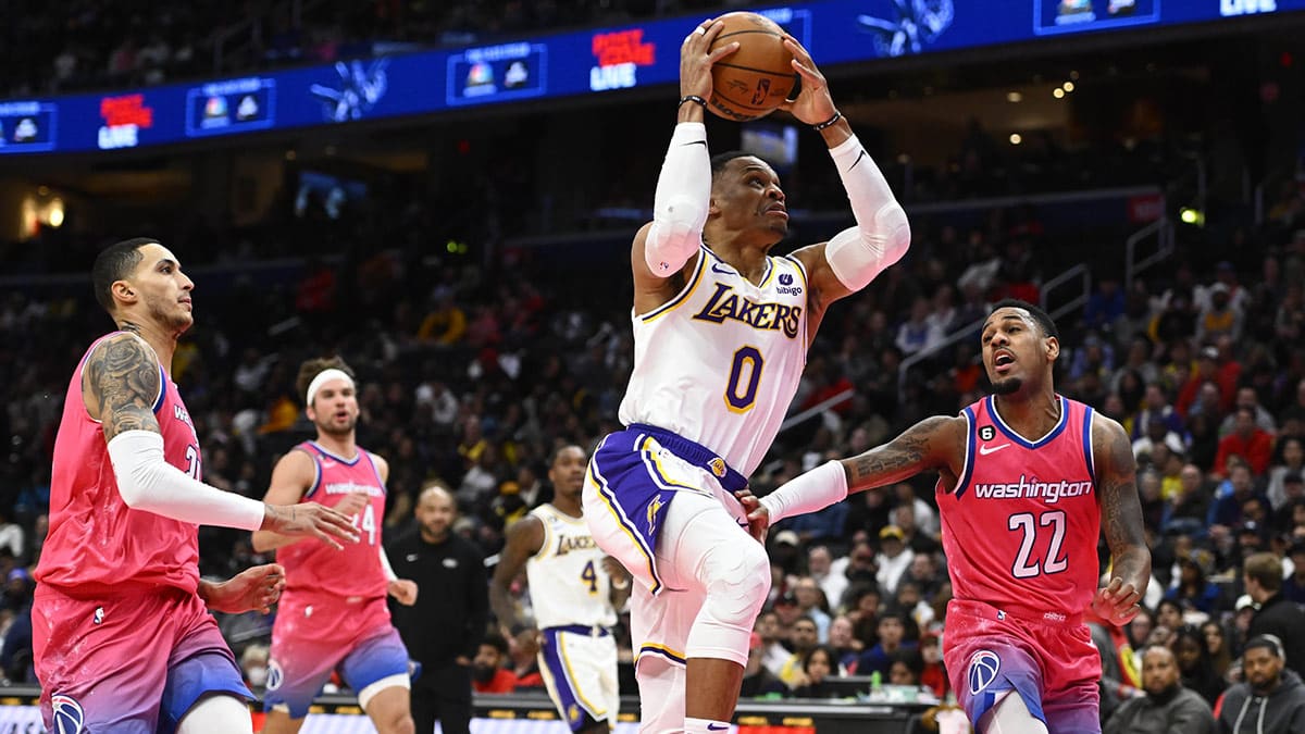 Los Angeles Lakers guard Russell Westbrook (0) shoots as Washington Wizards guard Monte Morris (22) and forward Kyle Kuzma (33) look on during the second half at Capital One Arena. 