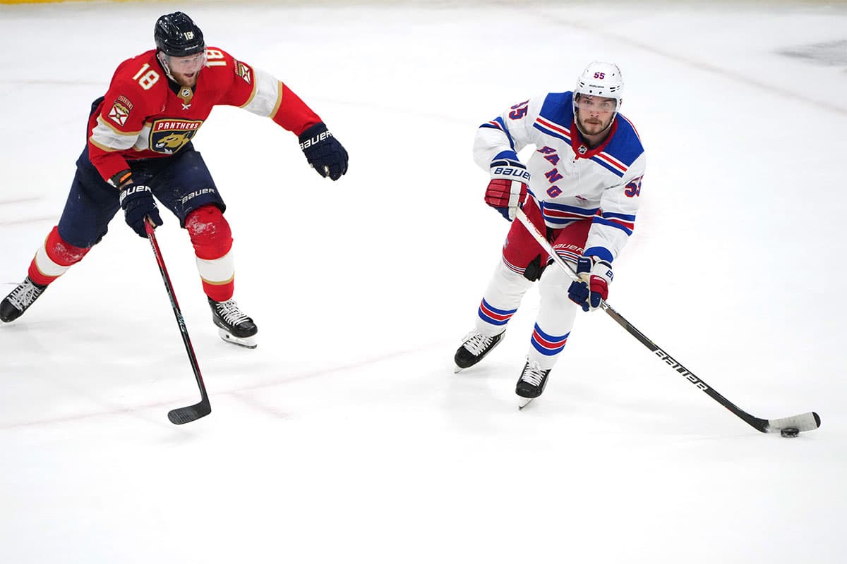 New York Rangers defenseman Ryan Lindgren (55) brings the puck up the ice as Florida Panthers center Steven Lorentz (18) closes in during the second period in game six of the Eastern Conference Final of the 2024 Stanley Cup Playoffs at Amerant Bank Arena.